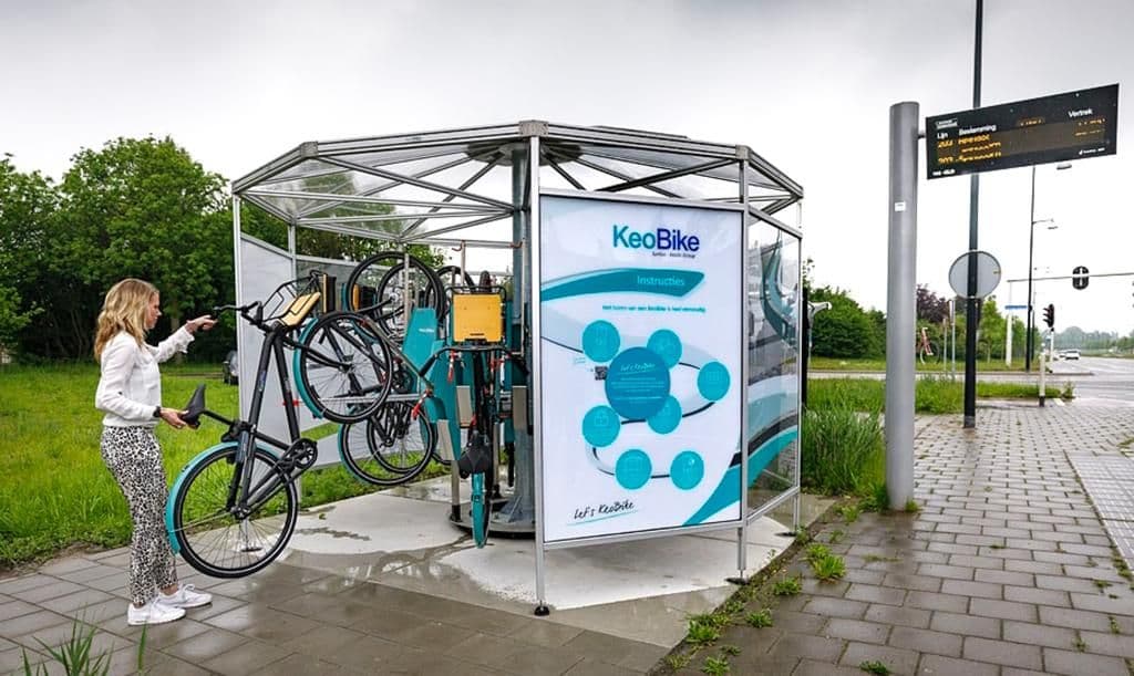 Een gebruiker die een deelfiets van Deelfiets Nederland in een KeoBike-rek plaatst