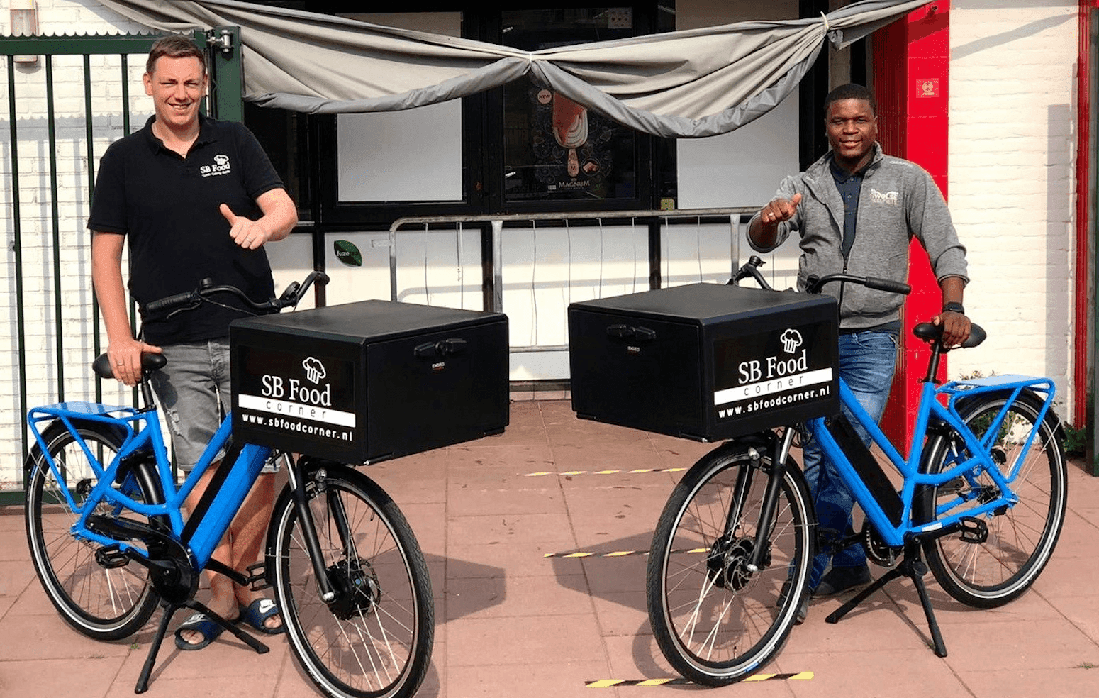 Oumar Sylla en een blije klant van de bezorgfietsen van Deelfiets Nederland, samen met de bezorgfietsen van Deelfiets Nederland